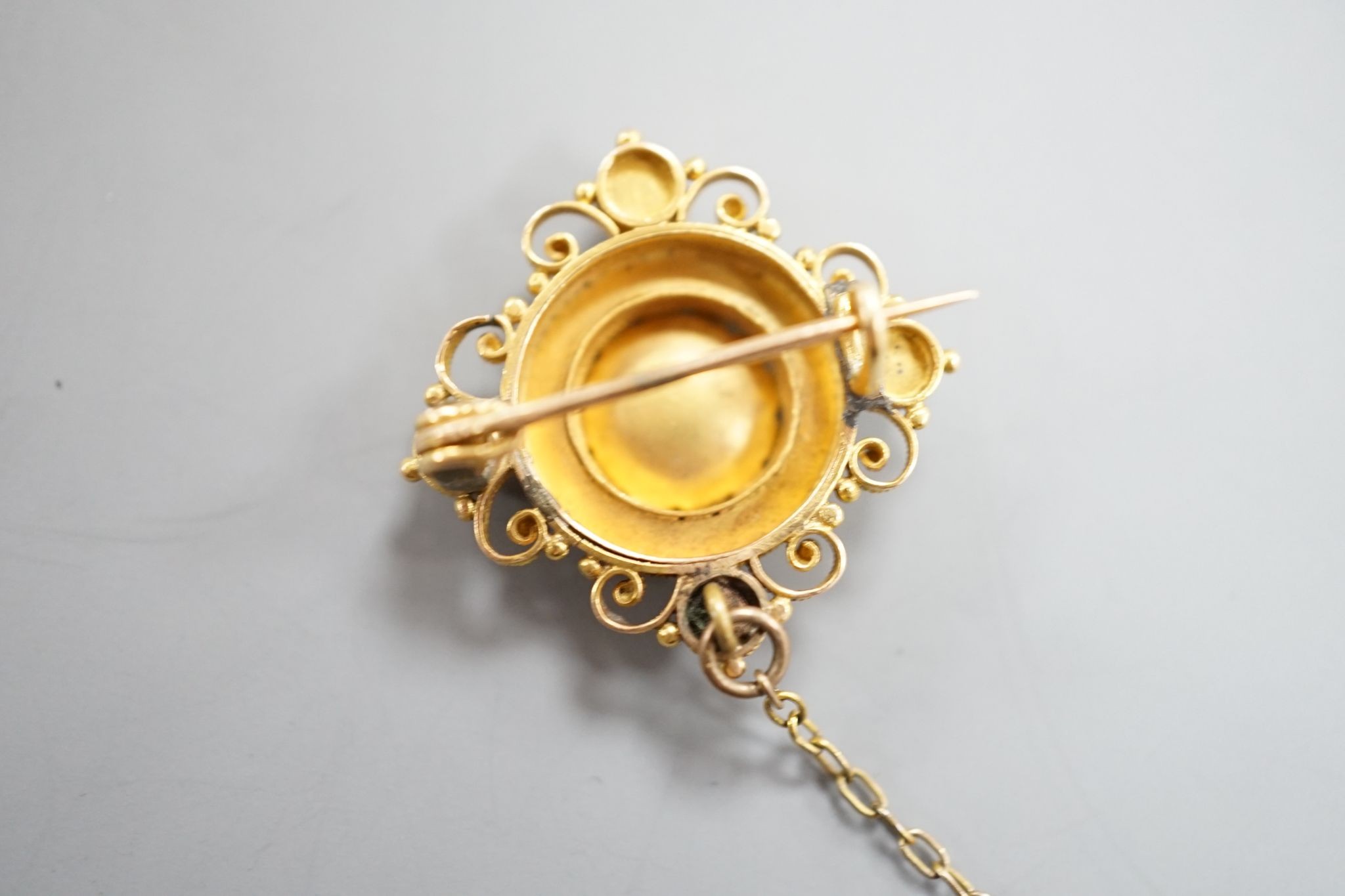 A Victorian cannettile work yellow metal and five stone ruby? chip set brooch, with safety chain, 17mm, gross weight 4.3 grams.